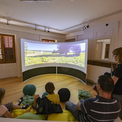 Des enfants regardent un film projeté sur un écran concave.